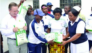 • BOXING sensation Catherine Phiri hands over a bag of rice to University Teaching Hospital (UTH) Nursing Officer Beauty Chibanga when the Oriental Quarries Boxing Promotion and Superior Milling donated food stuff to UTH mother’s shelter. Looking on is Superior Milling managing director Peter Cottan and mothers’ shelter chairperson Beatrice Chishimba. Picture by CLEVER ZULU