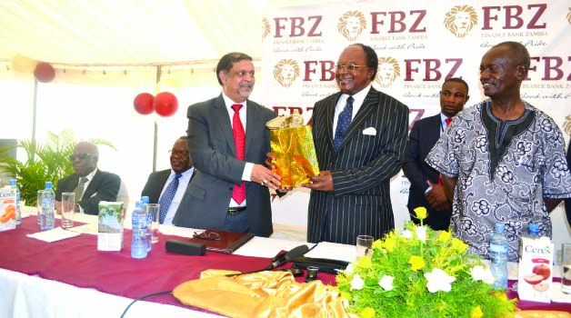 • BANK of Zambia Governor Michael Gondwe receives a gift from Finance Bank Zambia managing director and chief executive officer Barkat Ali, while out-going Copperbelt Permanent Secretary Stanford Msichili looks on. This was during the official opening of Finance Bank Jacaranda Branch and the launch of a new product-Makumbi Banking in Ndola yesterday. Picture by CHATULA KAMPO
