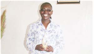 • Brenda Kunda captured in her office with an award she received from NGOCC on International Women’s Day for hard work and exellence.