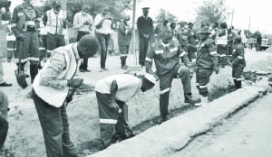 •LUSAKA Province Permanent Secretary Wamunyima Muwana (with raised leg), Lusaka District Commissioner Ashell Kampengele (in blue work suit, wearing hat) and Chawama Ward Two councillor Portipher Tembo (in grey trousers) when they joined Road Development Agency female members of staff to clean drainage facilities in Chawama Township in Lusaka on Thursday ahead of International Women’s Day celebrations. Picture by CHUSA SICHONE