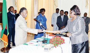 •PRESIDENT Michael Sata receives an affidavit of oath from newly appointed Tourism and Arts Minister Jean Kapata during the swearing in ceremony at State House in Lusaka yesterday. Picture by CLEVER ZULU