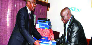 • Multichoice Zambia Board Chairperson Dr John Mulwila presenting an HD PVR decoder to the first Republican President Dr Kenneth Kaunda as a birthday present at MultiChoice office last week.