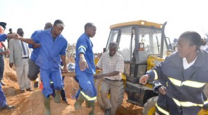 • FIRE brigade officers and police carry the body of a woman buried alive from the trench after being retrieved in Kitwe yesterday. Picture by MOFFAT CHAZINGWA  