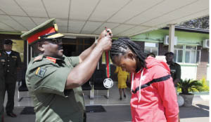 • ZAMBIA Army Deputy Commander Topply Lubaya honours athlete Kabange Mupopo at the Army Headquarters in Lusaka yesteday for her outstanding achievements in sports. Picture courtesy of the ZAMBIA ARMY