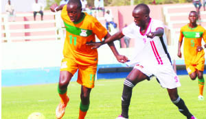 • ZAMBIA’S Enock Mwepu (left) in a tussle for the ball with Alex Kamokech Uganda during the Niger 2015 Africa Junior Championshis first leg match of the final round of qualifiers at Nkoloma Stadium in Lusaka recently. Zambia won 2-0. Picture by JEAN MANDELA