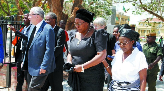 •ACTING President Dr Guy Scott  (left) with First Lady Dr Christine Kaseba (in black) during a wreath laying ceremony at President Sata’s grave at Embassy Park yesterday. Picture by THOMAS NSAMA