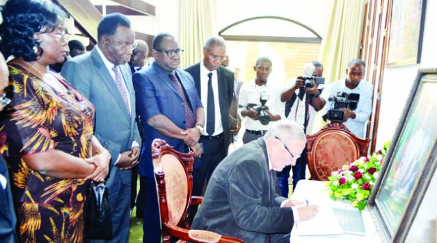 • ACTING President Guy Scott signs in the book of condolences which was opened at Government House in Lusaka yesterday. Picture by CHUSA SICHONEGovernment House in Lusaka yesterday. Picture by CHUSA SICHONE