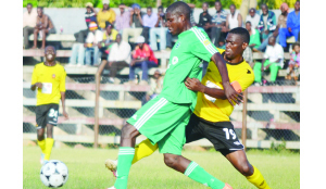 •GREEN Buffaloes’ Percy Bilyoti shields the ball from Power Dynamos captain Thomas Nyirenda during yesterday’s MTN-FAZ Super League match played at Woodlands Stadium. Power won 2-1. Picture by GWEN CHIPASULA