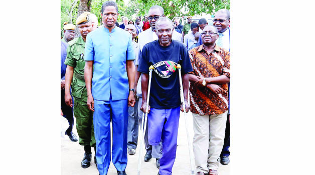 • President Edgar Lungu walking with a landmine victim in Ikeleng’i yesterday. Right is Foreign Affairs deputy minister Rayford Mbulu. Picture by EDDIE MWANALEZA/STATEHOUSE.