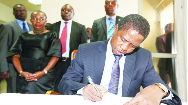 • President Edgar Lungu signs a book of condolences at the Ghanaian High Commission in Lusaka yesterday. Looking on is Ghanaian High Commissioner to Zambia Elizabeth Afua Benneh. Picture by EDDIE MWANALEZA/STATEHOUSE