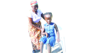 • JANE Bwalya being aided by her grandmother Rosemary Chilombo to sit on a chair. She suffers from an enlarged head, which has led to her blindness. Picture by MILDRED KATONGO