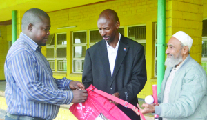 •LADY Diana Primary School representative Jotham Mumunga receives cricket starter pack from Zambia Cricket Union committee member Yandikani Ng’andu (centre) and life member Haroon Ghumra in Lusaka yesterday. Picture by GWEN CHIPASULA