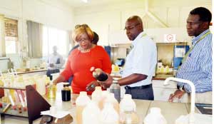 •INDENI managing director Maybin Noole (middle) shows Energy Minister Dora Siliya a sample of imported petrol waiting to be tested in the laboratory at the plant in Ndola on Tuesday this week. Picture by CHATULA KANGALI