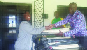 •ZAMBIA Cricket Union president Reuben Chama (right) hands over equipment to Lavendar Musukuma of Twatemwa Primary School.
