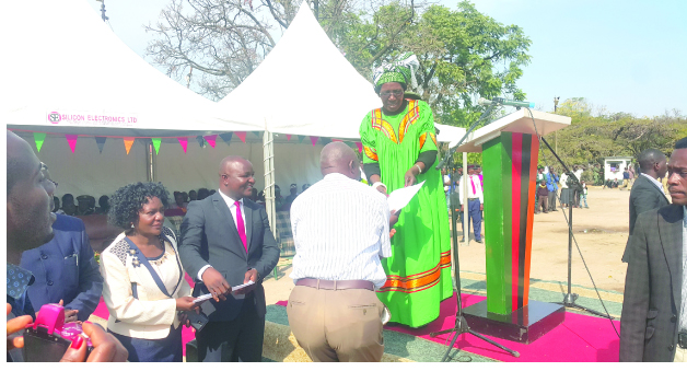 • VICE-President Inonge Wina hands over a letter of offer to one of the more than 4,000 former miners who have been empowered with land by Government. This was in Chingola yesterday. Picture courtesy of PROXIMITY MEDIA