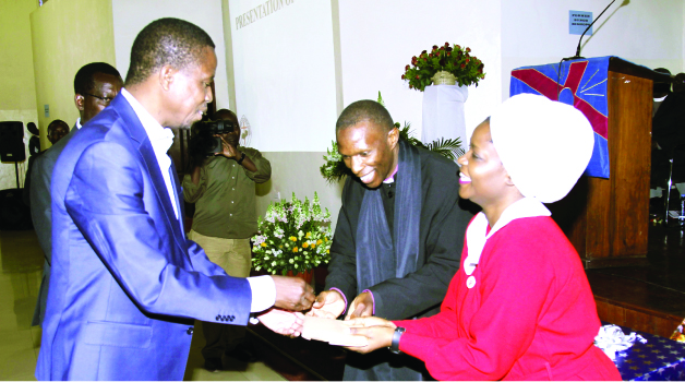 •PRESIDENT-Elect Edgar Lungu (left) receives a present from United Church of Zambia Synod Bishop Sydney Sichilima and his wife Ruby during a reception service at St Andrews Congregation in Lusaka yesterday. Picture by SALIM HENRY/STATE HOUSE