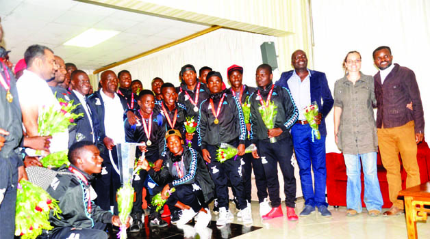 •THE triumphant Zambia Under-20 soccer team and officials pose with the COSAFA trophy on arrival at the Kenneth Kaunda International Airport  in Lusaka yesterday. Below the squad leaving the airport. Pictures by ADRIAN MWANZA 