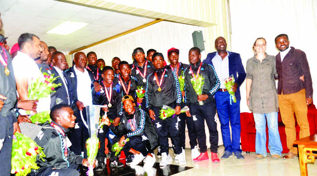 •THE triumphant Zambia Under-20 soccer team and officials pose with the COSAFA trophy on arrival at the Kenneth Kaunda International Airport in Lusaka yesterday. Below the squad leaving the airport. Pictures by ADRIAN MWANZA