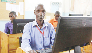 • An adult learner Mulima Mwandwa, 54, sits in front of a computer as other students are seen behind him at Lubengele Primary School in Chililabombwe.