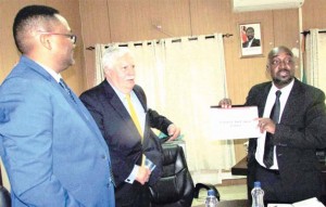 • TRANSPORT and Communications Minister Brian Mushimba (right) displays a copy of a business plan from Crowne Air Cargo Zambia chief executive director Douglas Berry (center) for setting up of a regional cargo airline in Zambia, while Zambia’s High Commissioner to South Africa Emmanuel Mwamba looks on in Lusaka yesterday. Picture by CHILA NAMAIKO 