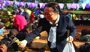 •A Zambia Chinese Association member hands over donated foodstuff to Open Arms Community School pupils recently.