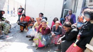 MARKETEERS gather outside the partially gutted City Market in Lusaka yesterday.