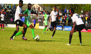 • Three City of Lusaka players charge-in on Mufulira Wanderers midfielder Fubani Muwowo (centre) during an MTN-FAZ premier division game at Woodlands Stadium that ended 2-2. Picture by Godfrey Dube