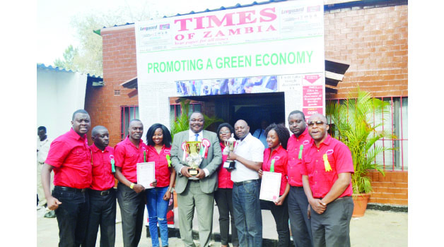 • THE WINNING TEAM...... Times Printpak employees with company managing director Beston Ng’onga (in suit) pose for a photo with two trophies after emerging best commercial exhibit and best media exhibit winners at the just-ended 91st Agriculture and Commercial Show of Zambia in Lusaka yesterday . Picture By JAJAH COULIBALY .