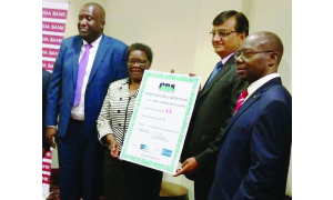 • INDO Zambia Bank (IZB) board chairperson Orlean Moyo (left) and IZB managing director Maheshkumar Bansal displays the credit rating certificate as IZB general manager Godwin Ngoma (far left) and Credit Rating Agency chairperson Wilson Kalumba (far right) look on. Picture by CASSEY KAYULA