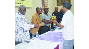 • MUNA Singh (right) presents a trophy to Induna George Zulu (left) for Chief Mpezeni (second from left) for supporting the Skyview Barn national motor rally at the weekend. Picture by ADRIAN MWANZA